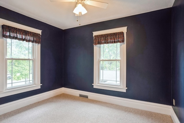 unfurnished room with ceiling fan, a healthy amount of sunlight, and carpet floors