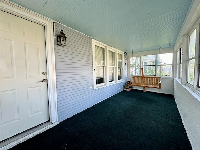 unfurnished sunroom featuring wood ceiling