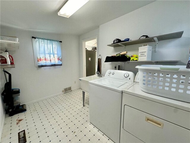 clothes washing area with light tile patterned flooring, an AC wall unit, and washer and dryer