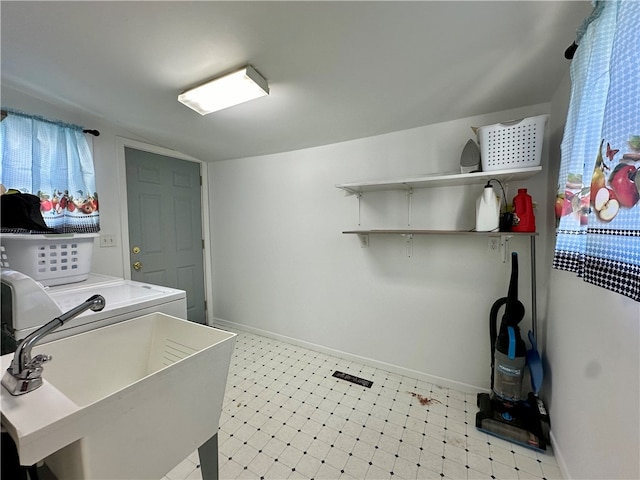 clothes washing area with sink, light tile patterned floors, and washer and clothes dryer