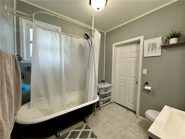 bathroom featuring tile patterned flooring, crown molding, shower / tub combo with curtain, and toilet