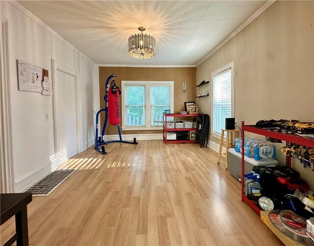 interior space with light wood-type flooring, a notable chandelier, and ornamental molding