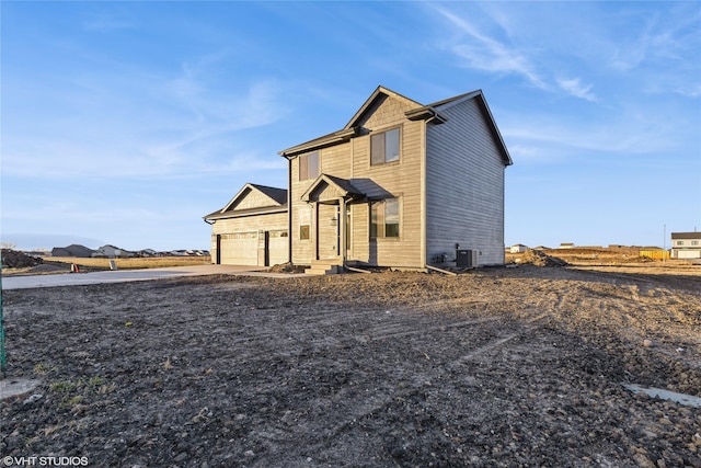 view of front of property with a garage and central AC unit