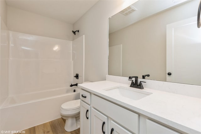 full bathroom featuring shower / bathing tub combination, wood-type flooring, vanity, and toilet