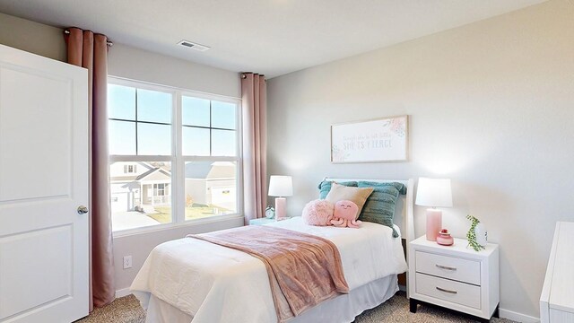 bedroom featuring visible vents, multiple windows, and light carpet