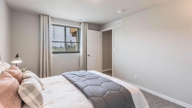 carpeted bedroom featuring visible vents and baseboards