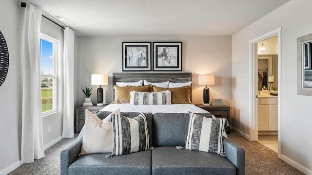 bedroom featuring carpet floors, baseboards, and ensuite bathroom