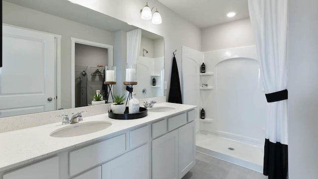 bathroom featuring double vanity, a sink, and a shower with curtain