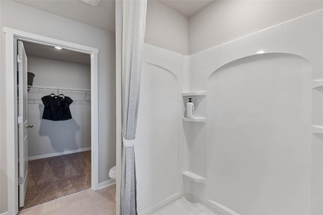 full bathroom with toilet, a shower, and a walk in closet