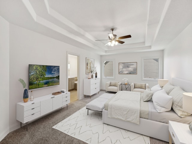 carpeted bedroom with ceiling fan, a raised ceiling, and ensuite bath