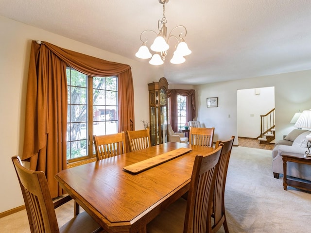 carpeted dining area with a notable chandelier