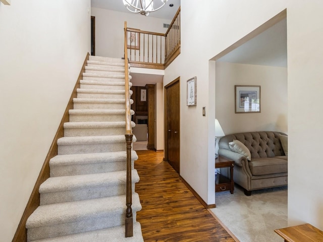 staircase featuring hardwood / wood-style flooring and a towering ceiling