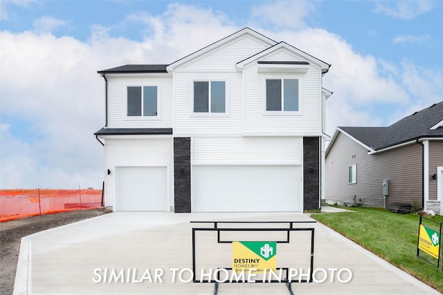 view of front of property featuring a front yard and a garage