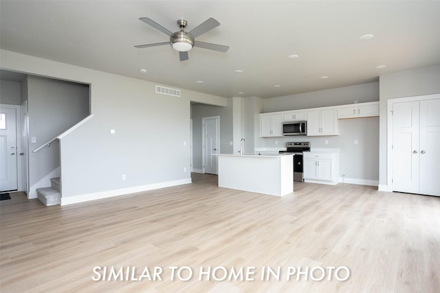 kitchen featuring visible vents, a ceiling fan, light wood-type flooring, appliances with stainless steel finishes, and white cabinetry