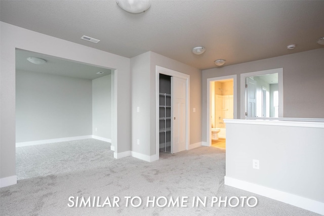 spare room with baseboards, visible vents, and carpet flooring
