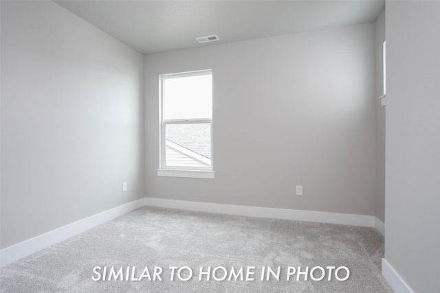 empty room featuring carpet floors, visible vents, and baseboards
