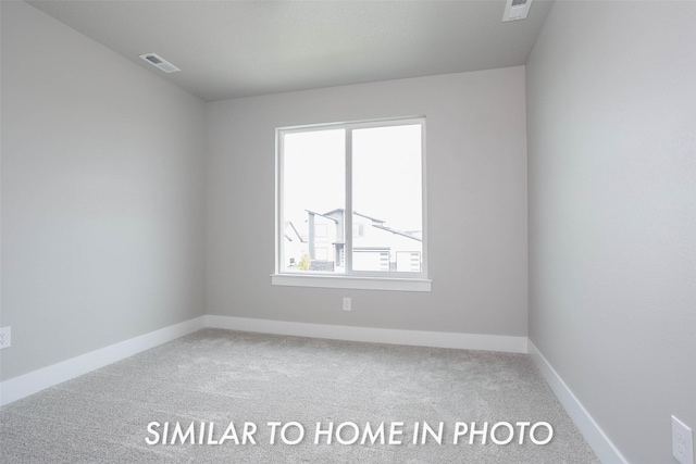 spare room with visible vents, carpet flooring, and baseboards