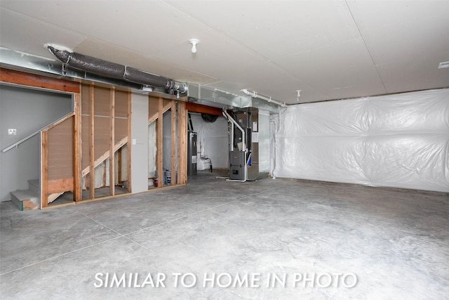 unfinished below grade area with heating unit, water heater, and stairway