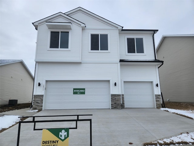 view of front facade with a garage and central AC