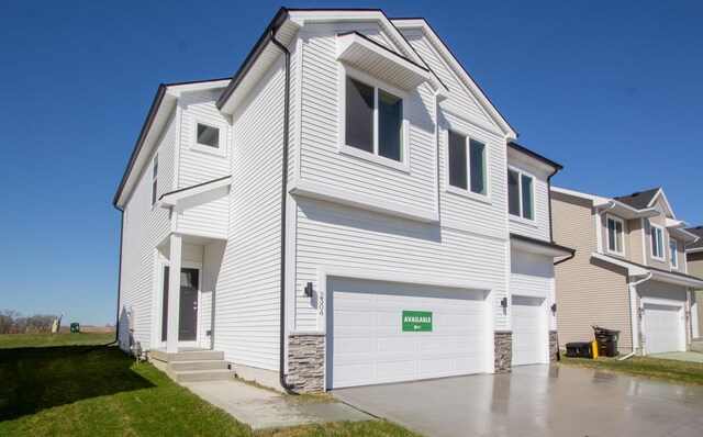 view of front of home featuring an attached garage, stone siding, a front lawn, and concrete driveway
