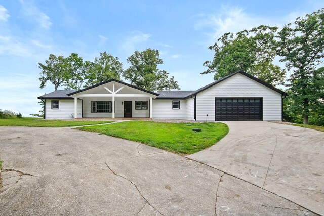 single story home featuring a front lawn and a garage