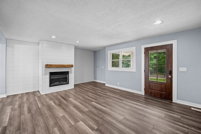 unfurnished living room featuring a textured ceiling and wood-type flooring