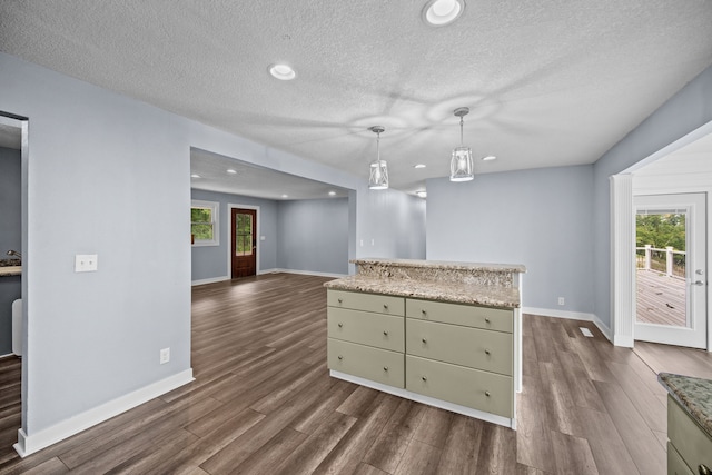 kitchen with a textured ceiling, decorative light fixtures, dark hardwood / wood-style flooring, and a kitchen island