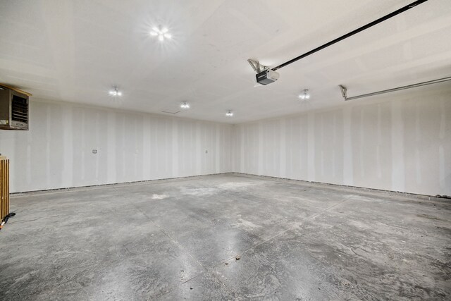 garage with a garage door opener and a wall mounted AC