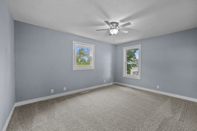 carpeted empty room with ceiling fan and a textured ceiling