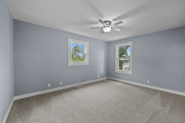 empty room with a textured ceiling, visible vents, baseboards, a ceiling fan, and carpet