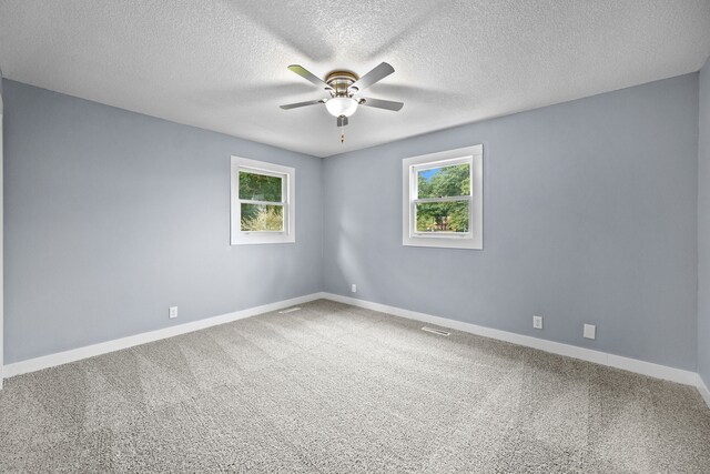 carpeted spare room featuring a textured ceiling and ceiling fan