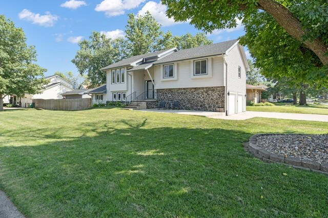 bi-level home featuring a garage and a front yard