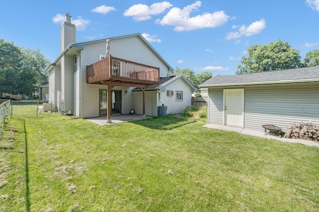 rear view of house featuring a patio area, a wooden deck, fence, and a yard