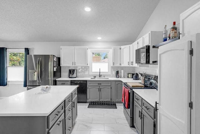 kitchen featuring gray cabinetry, a sink, light countertops, appliances with stainless steel finishes, and tasteful backsplash