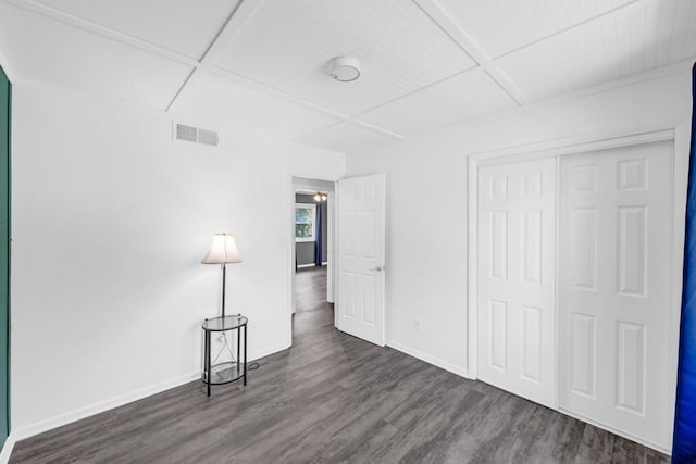 unfurnished bedroom featuring dark wood-style floors, baseboards, visible vents, and a closet