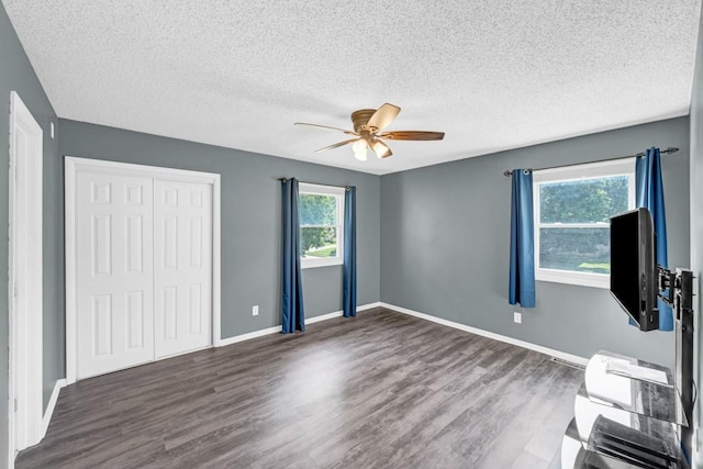 unfurnished bedroom featuring a ceiling fan, a closet, baseboards, and wood finished floors