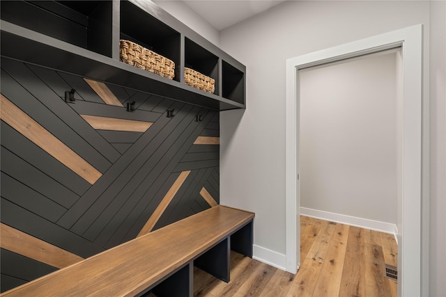 mudroom with light wood finished floors, visible vents, and baseboards