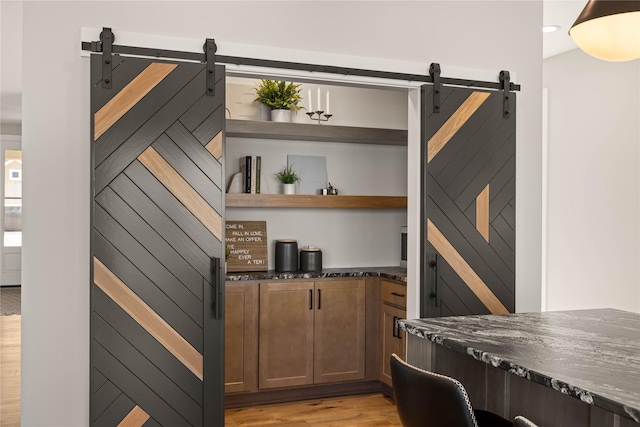 interior space with a barn door and light wood-style flooring