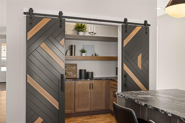 1185 NW 28th St, Grimes, IA 50111 - bar area featuring a barn door and light wood finished floors