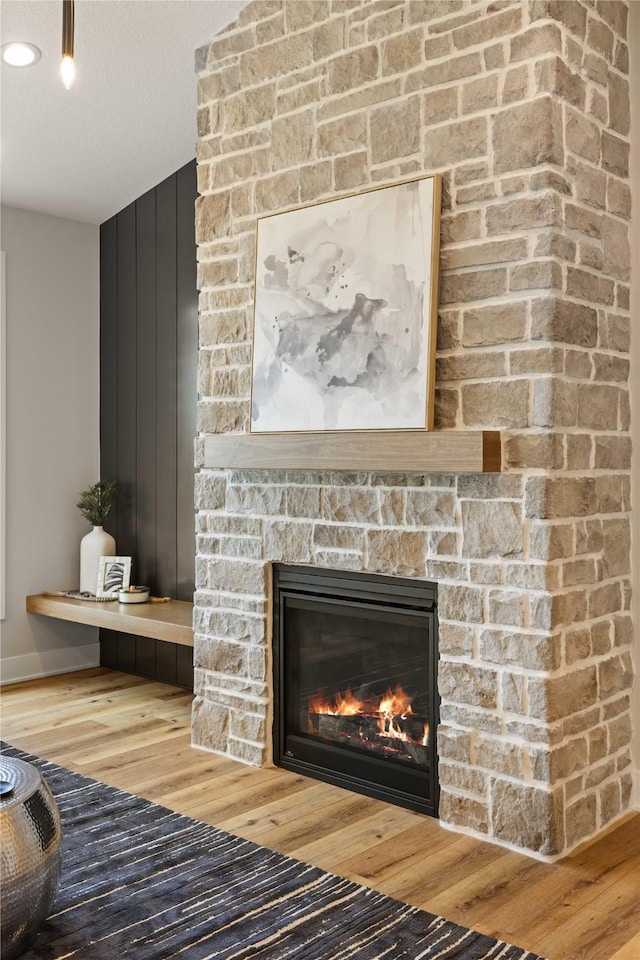 room details with a textured ceiling, a fireplace, and wood finished floors