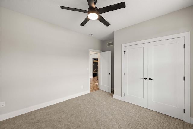 unfurnished bedroom with ceiling fan, visible vents, baseboards, a closet, and carpet