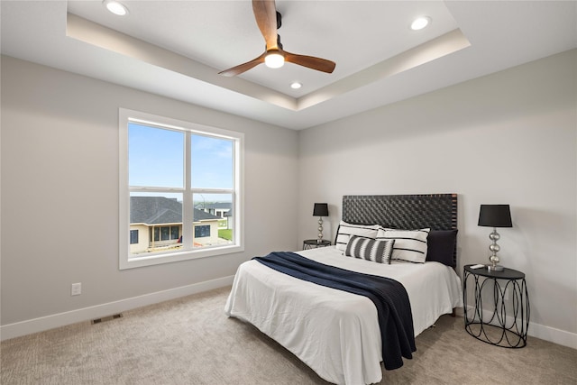 bedroom featuring recessed lighting, carpet flooring, visible vents, baseboards, and a tray ceiling