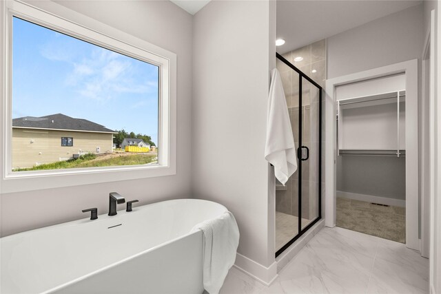 1185 NW 28th St, Grimes, IA 50111 - bathroom featuring marble look tile flooring, a stall shower, a freestanding bath, baseboards, and recessed lighting