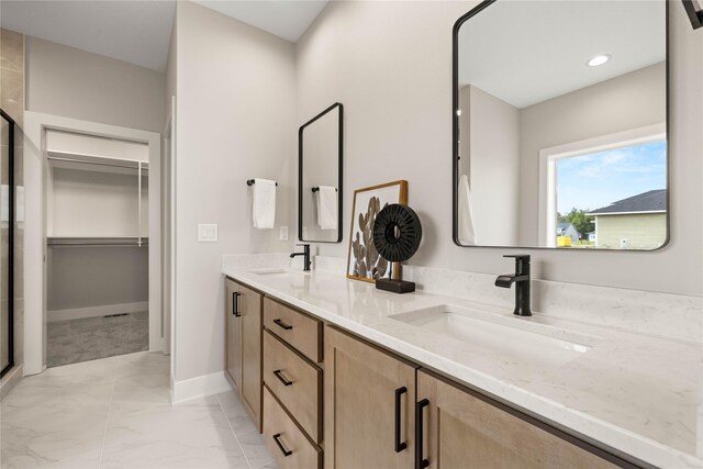 1185 NW 28th St, Grimes, IA 50111 - bathroom featuring marble look tile flooring, a shower stall, a walk in closet, double vanity, and baseboards