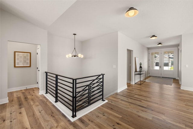 entryway featuring french doors, baseboards, a notable chandelier, and hardwood / wood-style floors