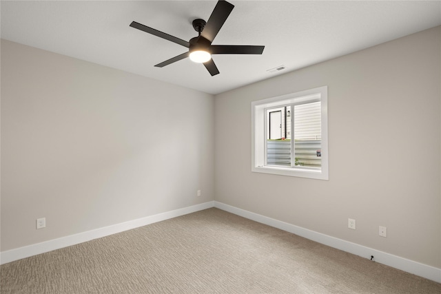 empty room with ceiling fan, carpet flooring, visible vents, and baseboards