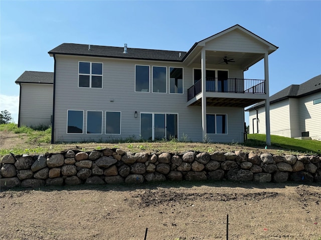 back of property featuring a balcony and a ceiling fan