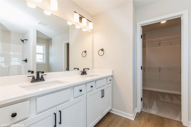 bathroom with wood-type flooring, vanity, and walk in shower