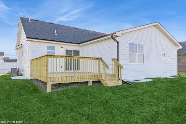 rear view of house with a deck, a yard, and central air condition unit