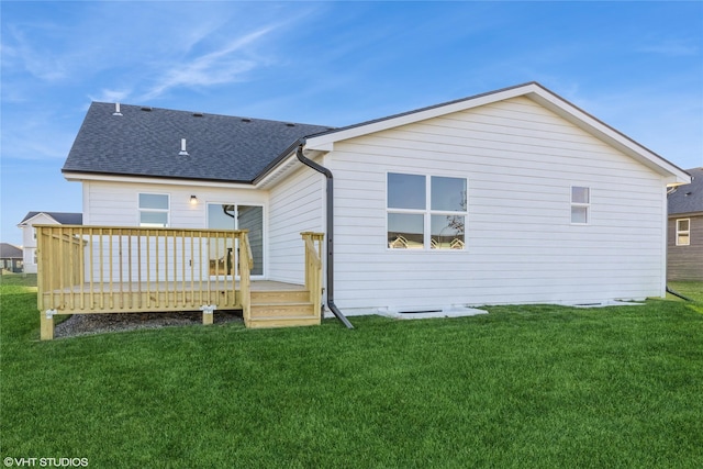 back of property featuring a wooden deck and a yard